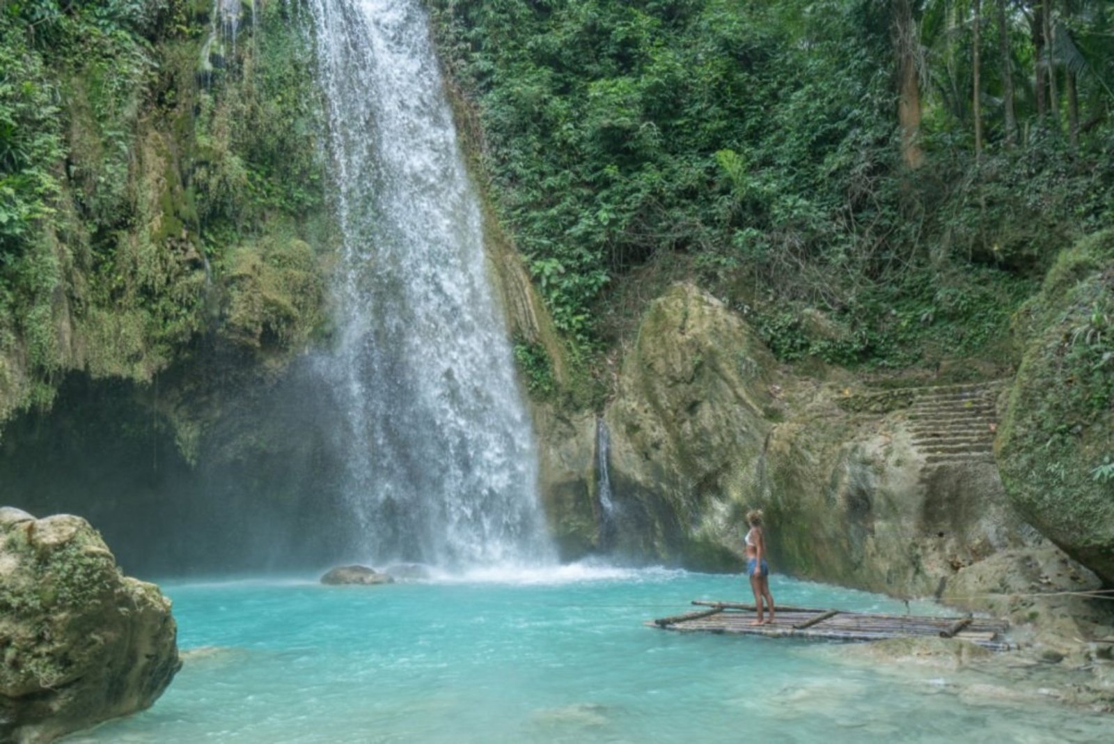 Girl contemplating beautiful waterfall