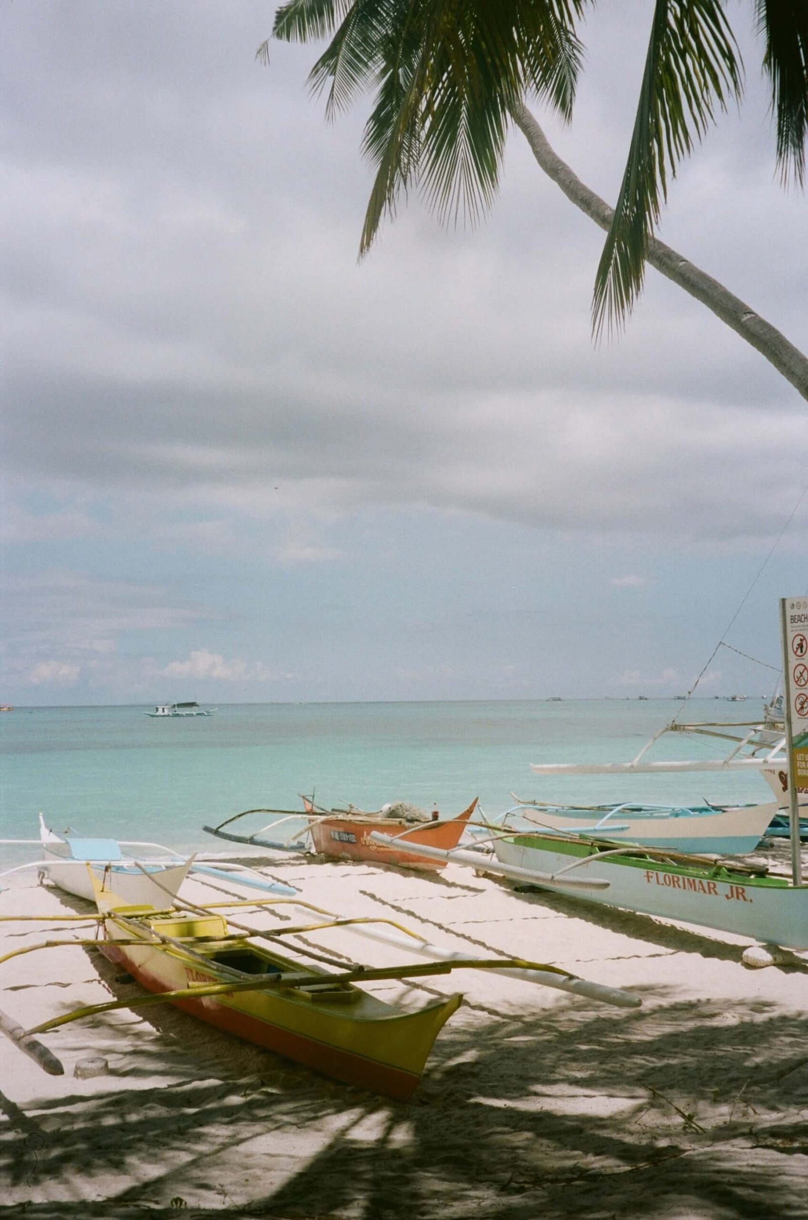 Colorful outrigger boats resting on the sand of a Boracay beach
