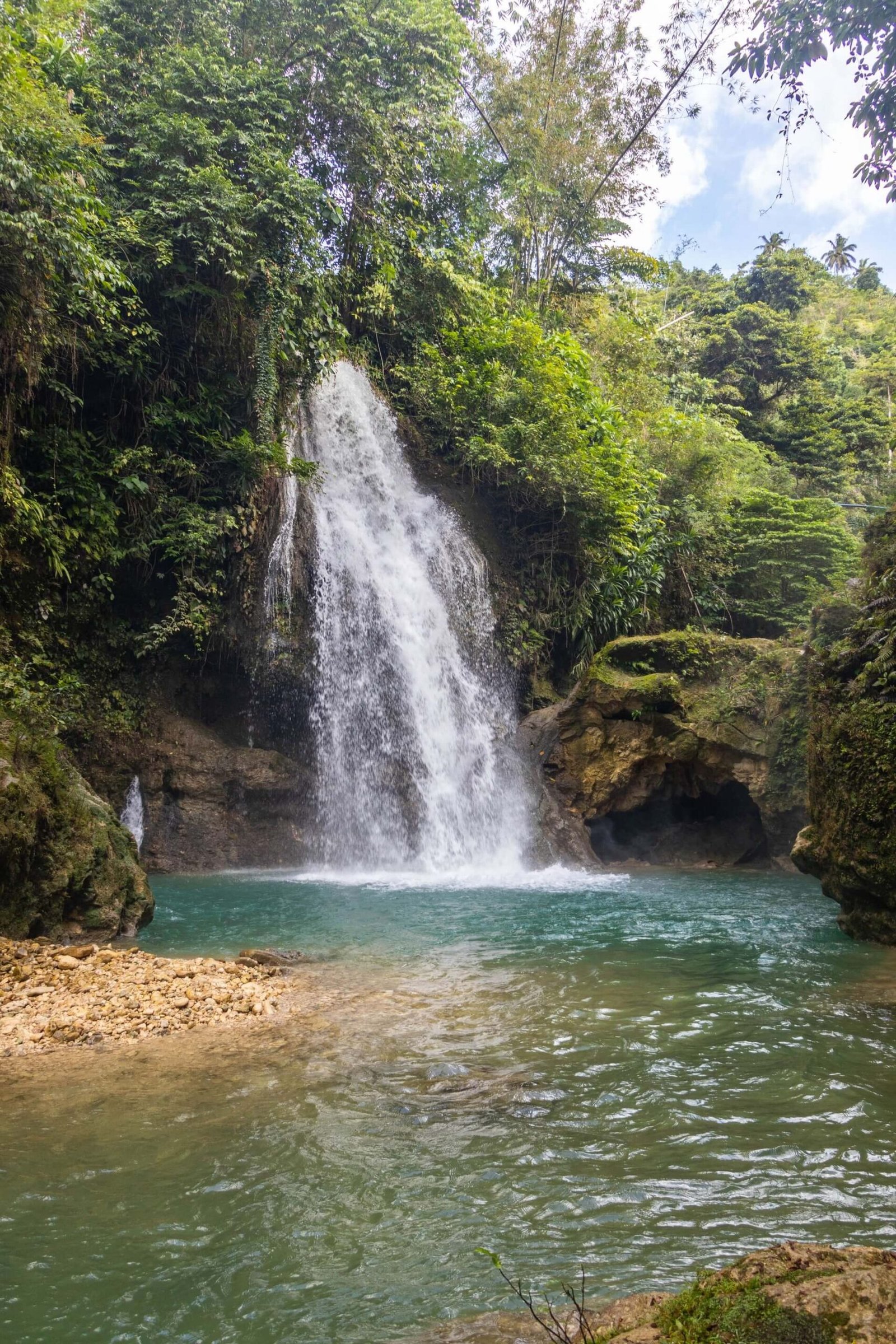 Kawasan Falls pouring into a blue pool surrounded by jungle in Cebu, Philippines